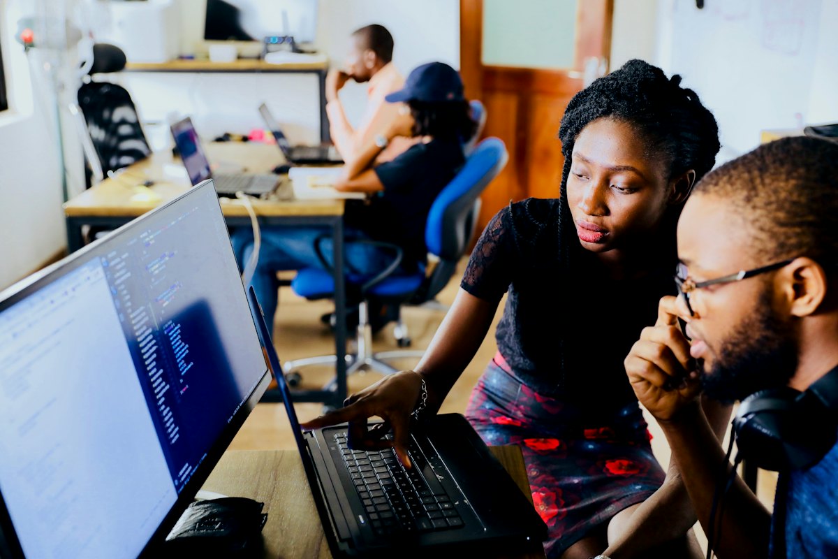 Two colleagues working through a problem at a computer
