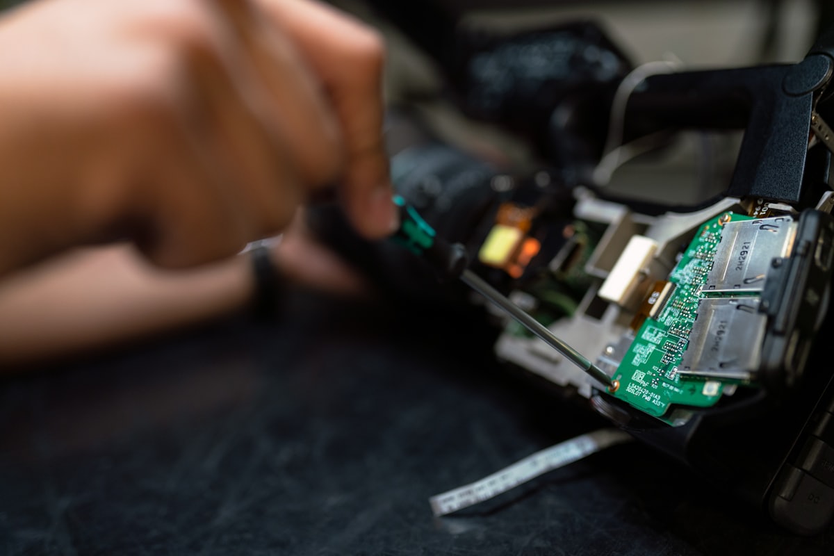 Technician repairing a device with a screwdriver